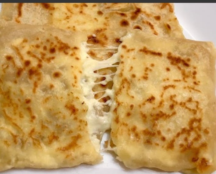 Cheese paratha pulled apart with melting cheese